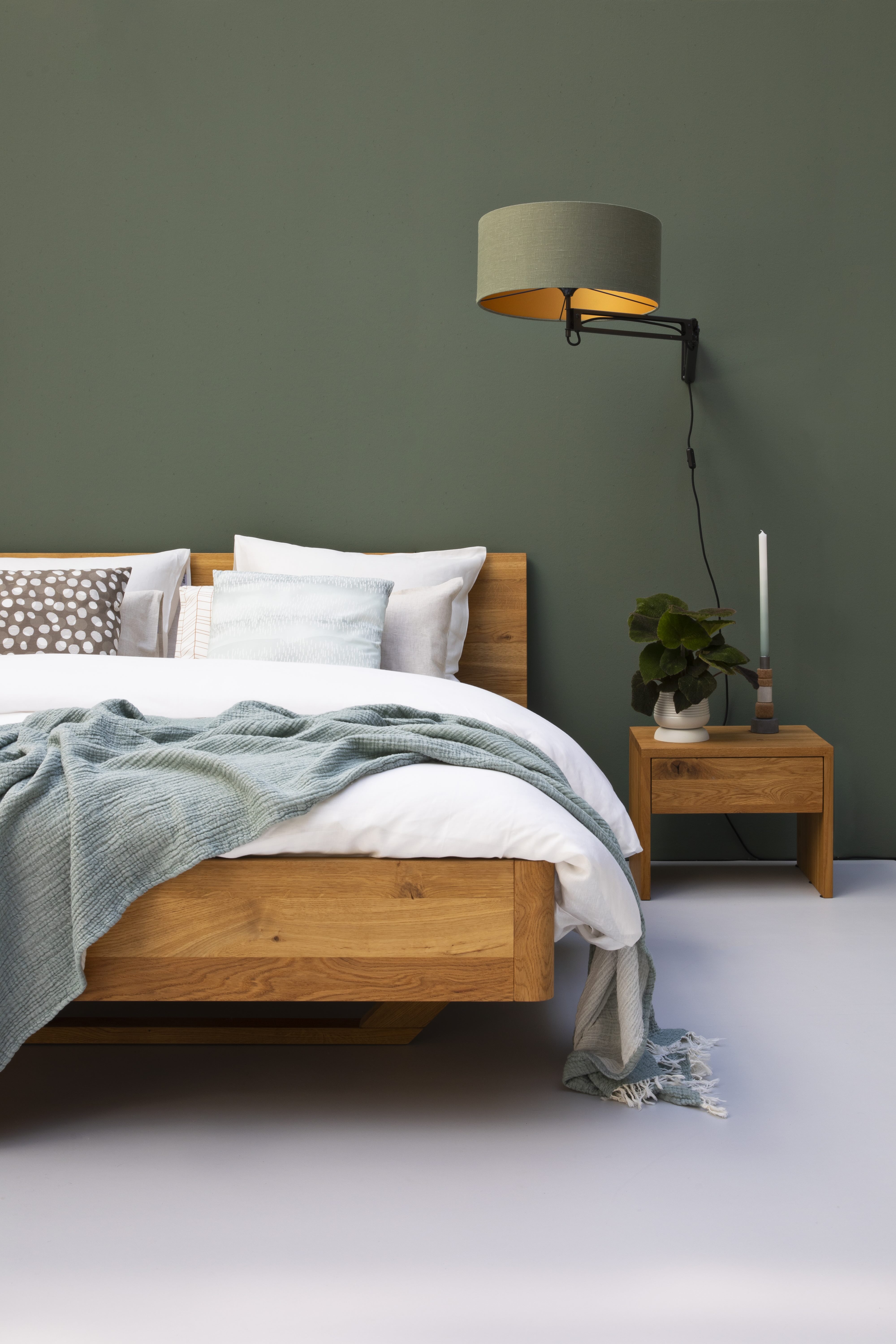 Licht bed met henneplinnen voor een groene wand